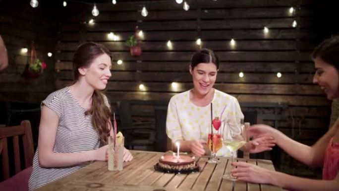 令她的朋友感到惊讶的是，服务员将生日蛋糕带给了一个快乐的女人
