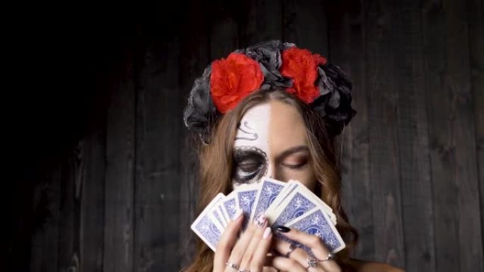 骷髅头化妆的女模特在木墙上展示卡片