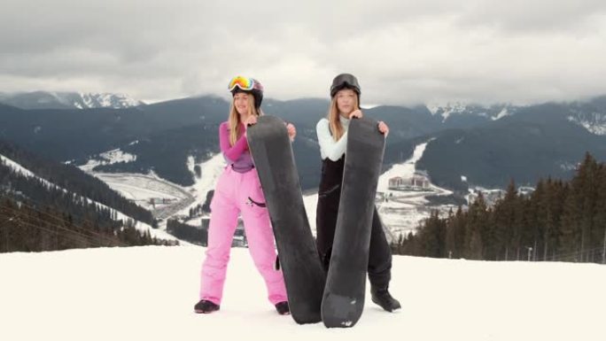 两个穿着滑雪板的时尚女人在山上