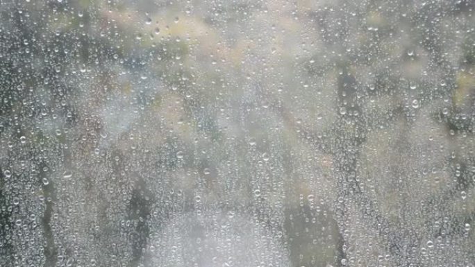 窗外正在下雨，落在玻璃上的新水滴滚落