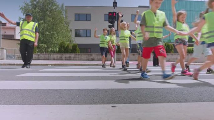 LD一群学童在过马路警卫的帮助下学习如何安全过马路