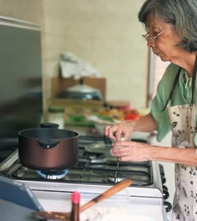 亚洲资深女性从互联网上学习烹饪
