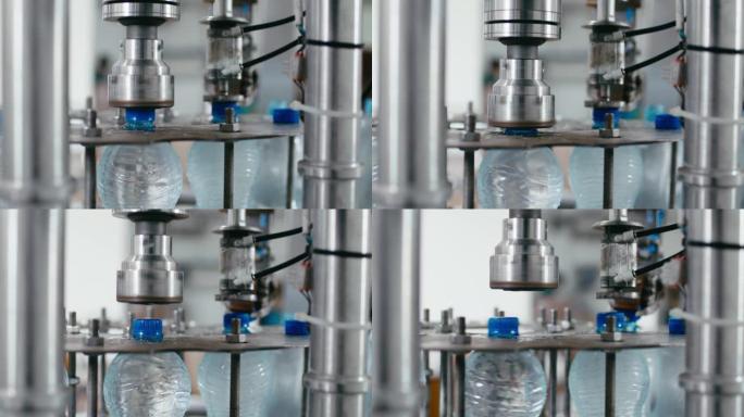 水厂工业机器在带水的塑料pet瓶上盖上盖子，特写