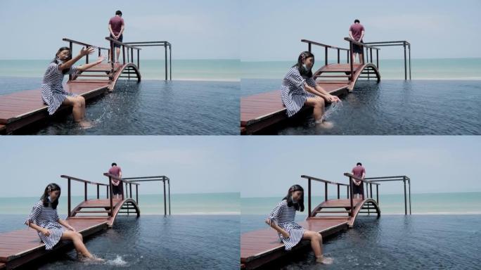 快乐的亚洲女孩在度假期间在酒店游泳池附近放松时泼水，生活方式理念。
