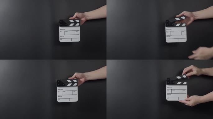 电影拍板镜头。在拍摄或录制之前，男人会手持胶片石板并在工作室鼓掌。用于视频录制的电影拍板或电影石板。