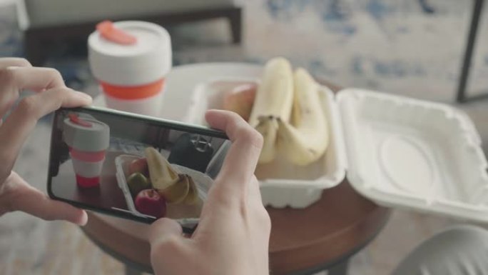 女人在餐馆里拍摄食物。特写镜头。