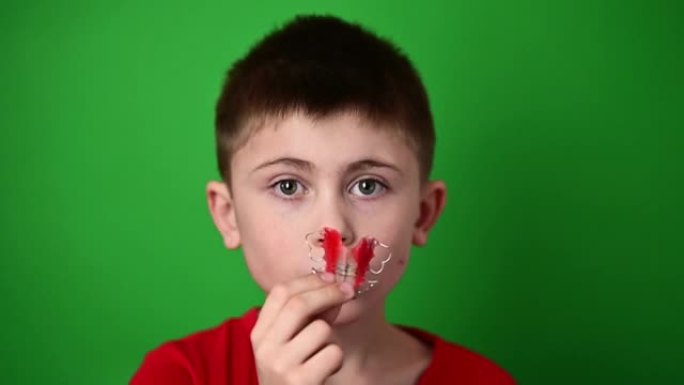 一个9岁的男孩拿着一个牙科配位板，一个可憎的东西和一个牙科配位板的演示。