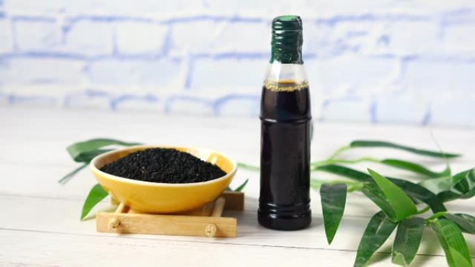 黑色小茴香放在容器里，油放在桌子上的罐子里。