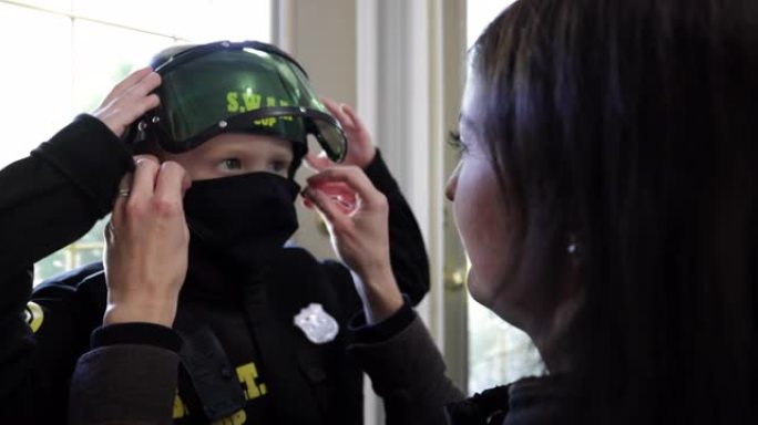 戴着防护口罩和警察服装的小男孩准备在万圣节期间捣蛋