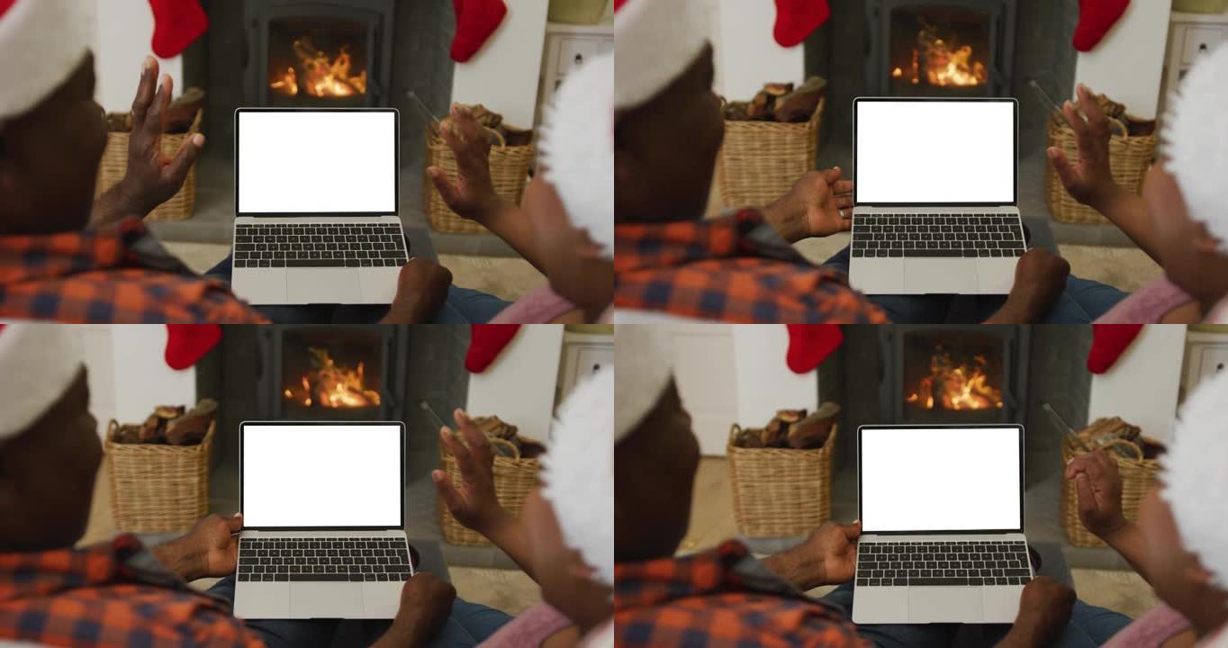 戴着圣诞老人帽子的非洲裔美国夫妇进行笔记本电脑圣诞节视频通话，屏幕上有复制空间