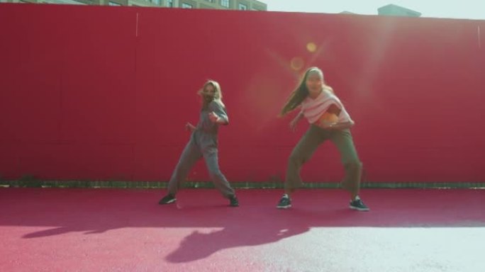 舞蹈学校广告。女舞蹈家教练，十几岁的儿童女孩火红的活力舞蹈在阳光下在外面移动
