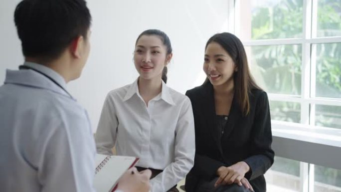 一位亚洲男性整形外科医生的肖像与一位女性患者交谈，在诊所办公室咨询医学和保健概念。