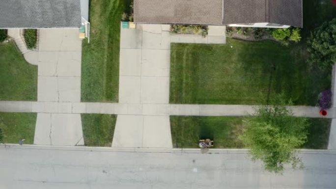 草坪拖拉机从院子上方割草的空中无人机视图