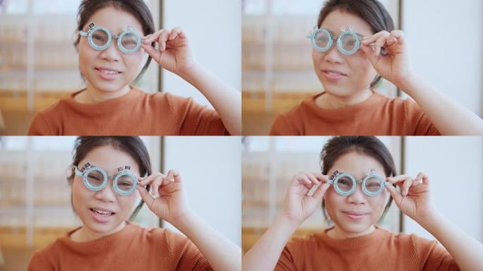 眼科医生用验光师试验框架检查有吸引力的亚洲女性。亚洲女性患者在眼科诊所检查视力光学商店背景