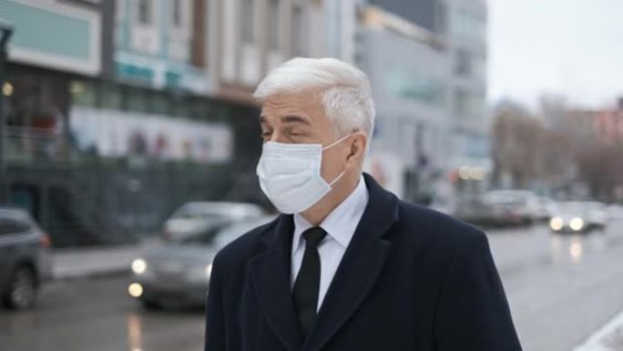 新型冠状病毒肺炎病毒大流行期间，穿着外套、领带和口罩的商人在街上。