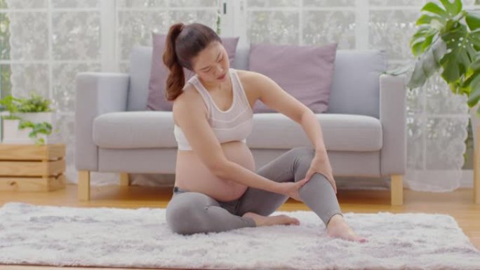 孕妇抚触和按摩小腿腿部如此疼痛和突然抽筋，怀孕的妇女患有小腿腿部抽筋，醒来后肌肉受到压力，怀孕的保健