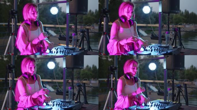 酷dj在一家夜总会工作，站在转盘上，制作舞蹈音乐套装-夜生活概念4k镜头。