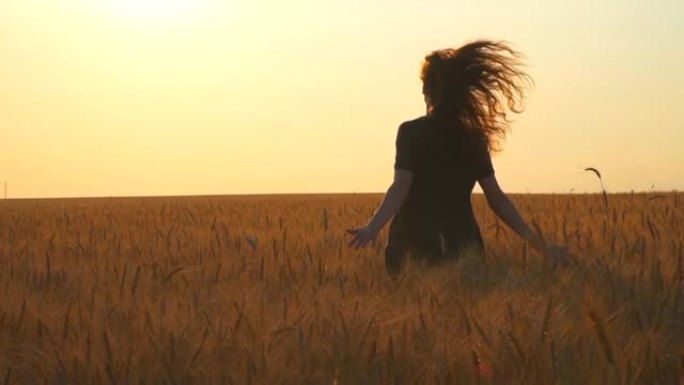 女人在日落时分跑到田野的阳光明媚的地平线上。年轻的高加索女孩夏天在户外玩得开心。晴天和光线。后面的女