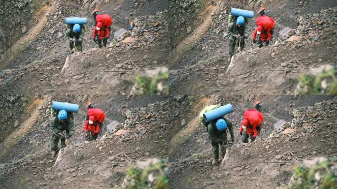 登山者带着装备的背包爬山，用带绳索的登山扣固定在一起。