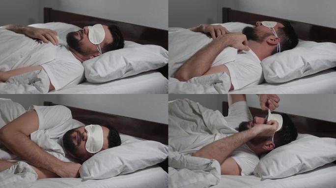 白人大胡子男人上床睡觉，在灯光室醒来的特写镜头。有魅力的家伙上床睡觉。戴口罩睡觉。早上好冷静觉醒4k