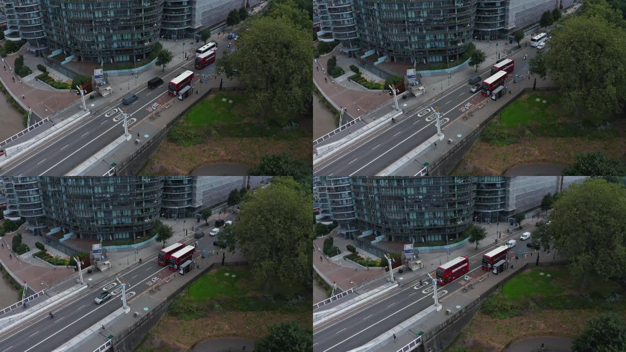 街道上交通的下降镜头。提供公共交通的典型红色双层。沿街的现代公寓楼。英国伦敦