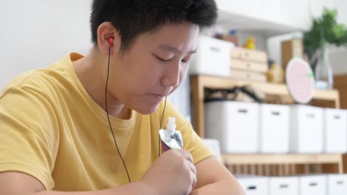 亚洲男孩在家学习在线课程时做作业，生活方式理念。