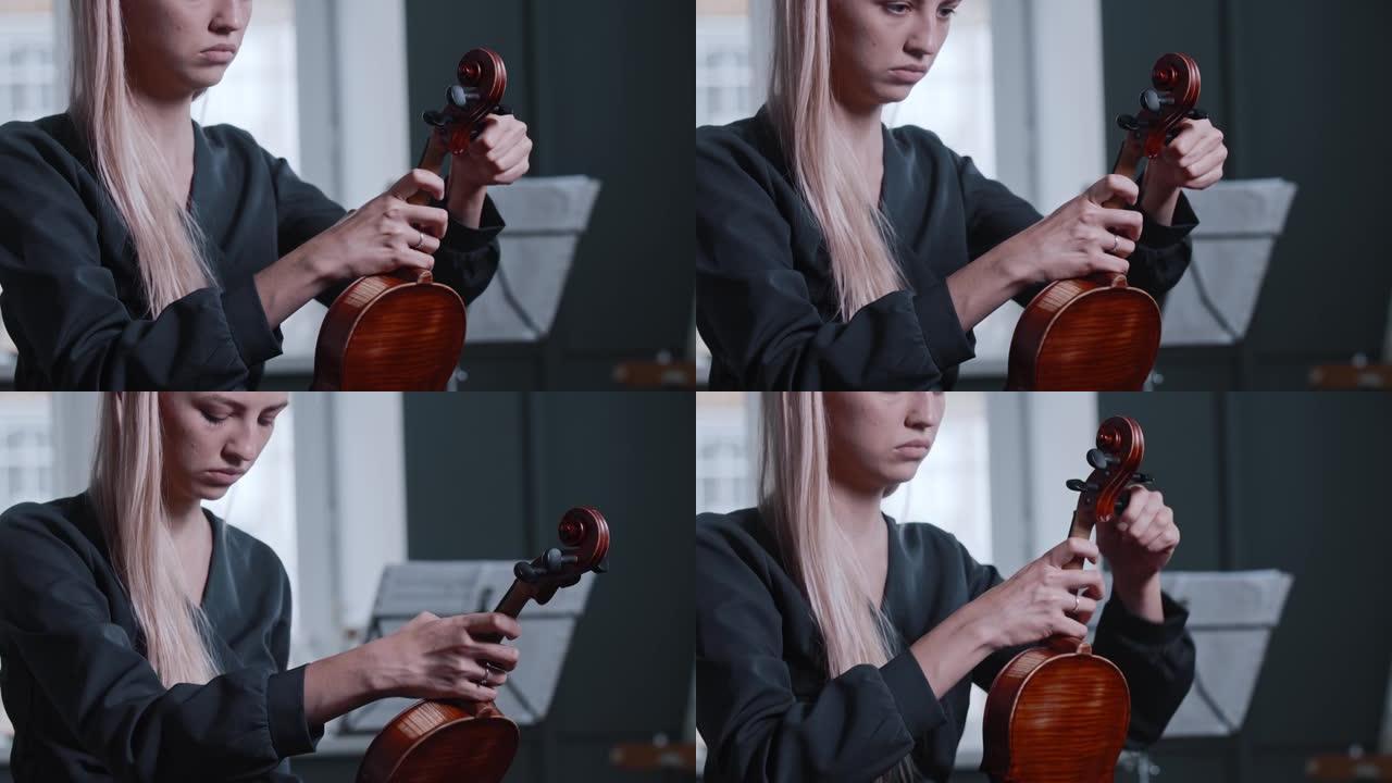 年轻的金发女子调小提琴