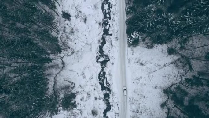 高架俯视图汽车在山间森林的雪道路上行驶