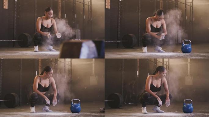 4k视频片段，一名年轻女子在健身房举起壶铃前给双手打粉。