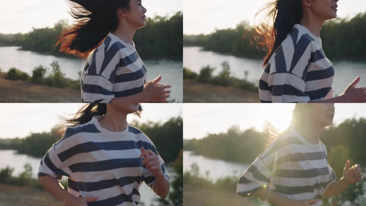特写运动员美丽的亚洲女人快乐地沿着自然河流慢动作奔跑，一头黑发在空气中流动，平静快乐纯粹的幸福与自然