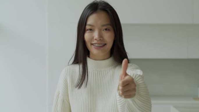 亚洲女子微笑着对镜头竖起大拇指