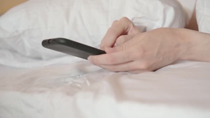 女人把智能手机和上网躺在床上