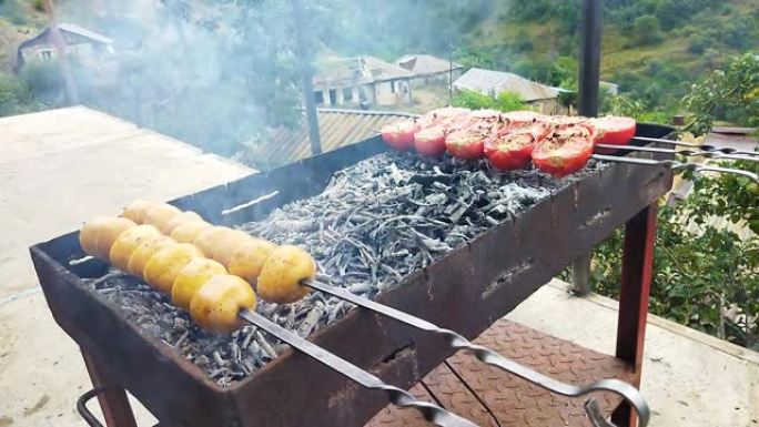 在火上煮土豆和西红柿。好胃口。夏天的菜，土豆和西红柿在火上。炸薯条着火了。亚美尼亚美食