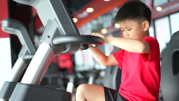 亚洲男孩在健身房用拳击和自行车锻炼微笑