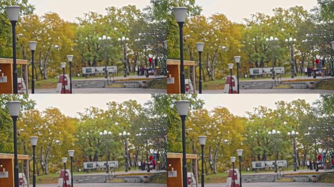 模糊的软焦点视图城市公园与商店路灯人们在秋季Avki