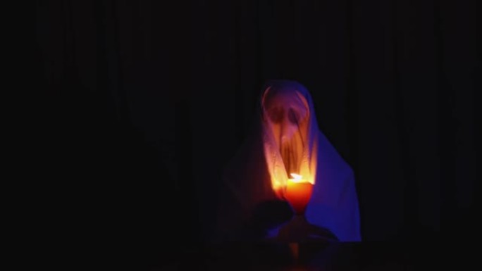 万圣节嘉年华庆祝派对概念: 家庭幽灵服装，燃烧蜡烛