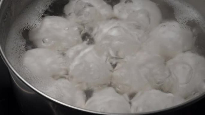 在不锈钢锅中煮沸的白色鸡蛋