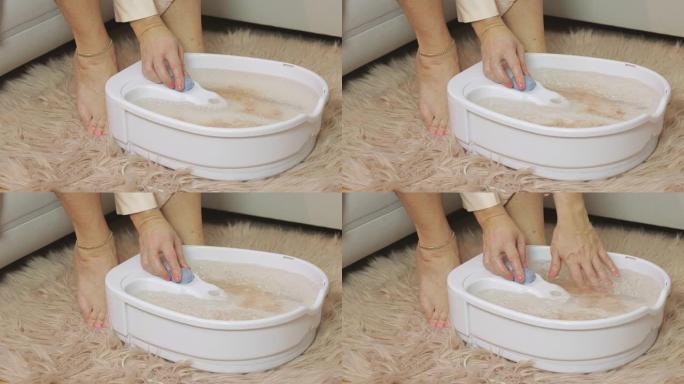 女人在按摩足浴中检查水的振动力