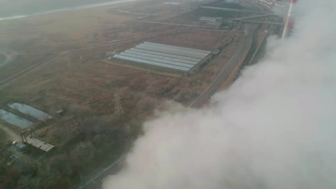 工业区管道的空中轨道视图倾泻着浓浓的白烟。浓烟。火电厂管道，空气污染。