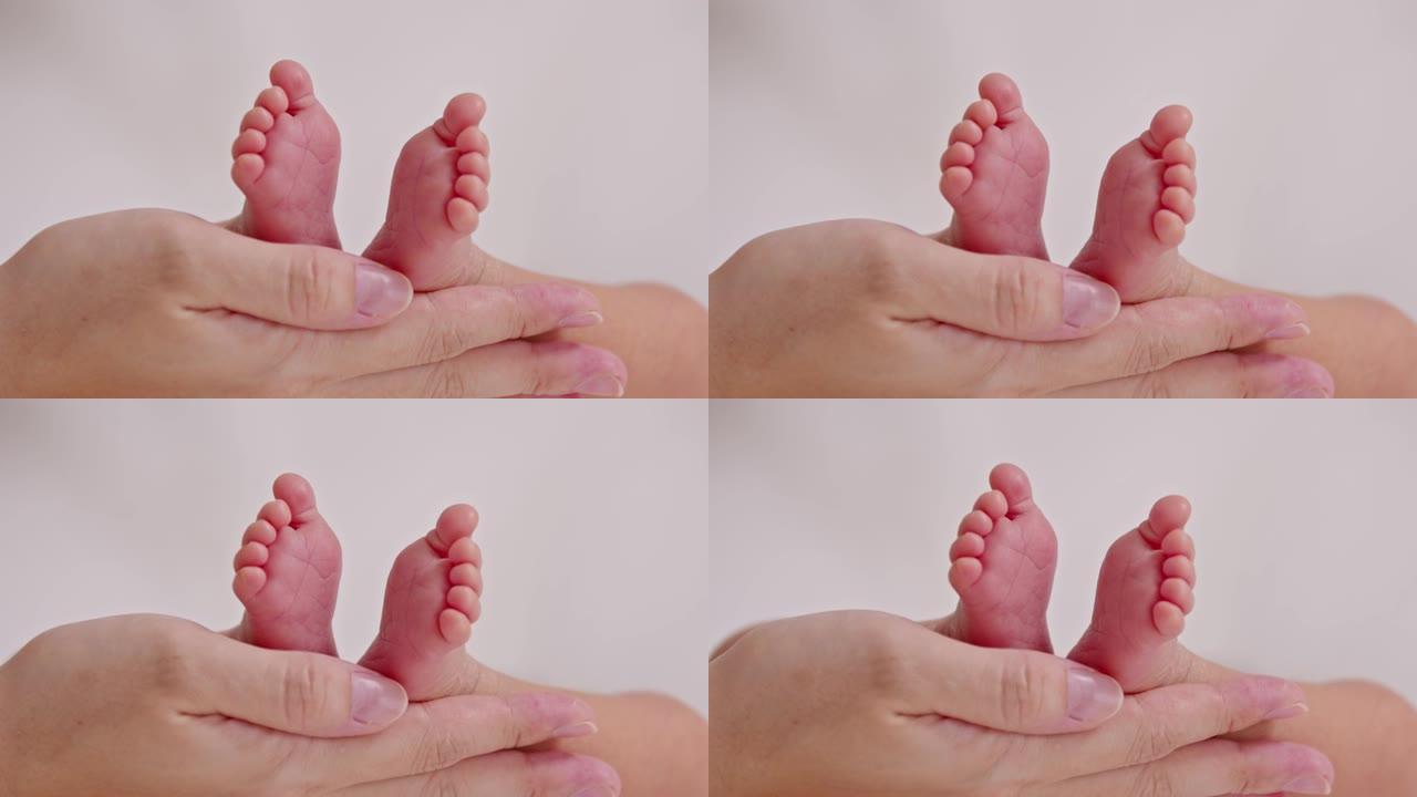 母亲用爱心托着婴儿新生的脚。父母在舒适的家中手握着小巧的婴儿脚。舒适的心情和语气。母亲和新生婴儿护理