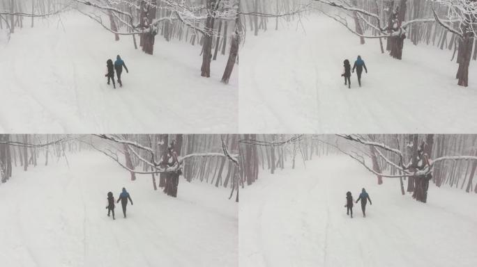 追踪后景情侣牵手一起走在被白雪皑皑神秘宁静景观包围的冬季森林里。佐治亚州精彩的萨巴杜里森林