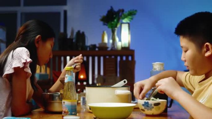 亚洲孩子晚上在家和家人一起吃sha锅或寿喜烧，生活方式理念。
