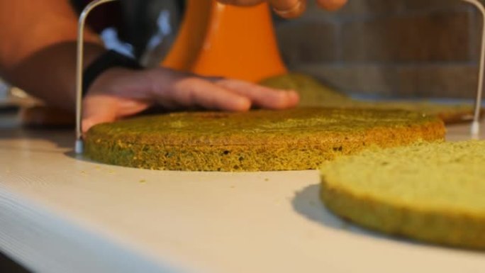 面包师的手将菠菜饼干切成小刀切片机。