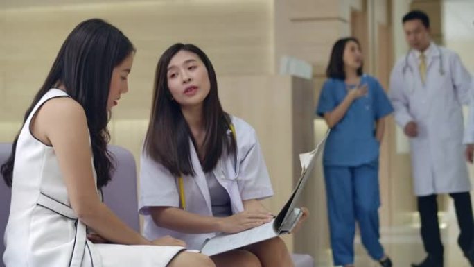 年轻女性医生在医院与年轻女性患者谈论和解释医学检查结果和诊断。
