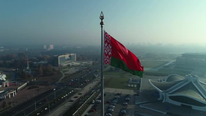 晴朗的早晨，白俄罗斯国旗飘扬在蔚蓝的天空和明斯克的城市景观上