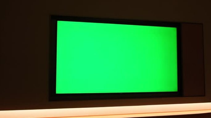 人们在漆黑的夜晚观看大型绿屏电视