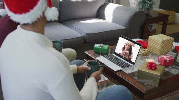 混血儿父子使用笔记本电脑进行圣诞节视频通话，屏幕上有微笑的女人