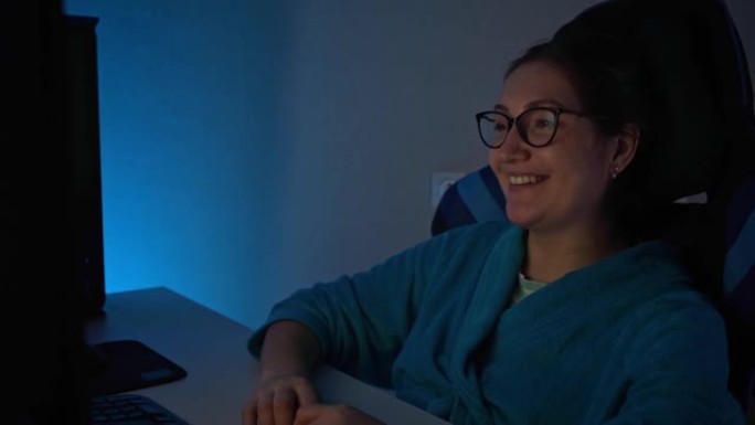 女人通过计算机观看电视连续剧，笑容灿烂