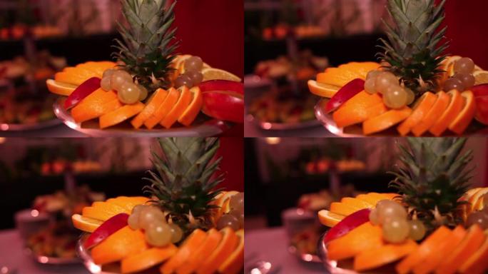 多层托盘上的混合水果排列。显示的水果包括葡萄，西瓜，菠萝，甜瓜，酸橙和其他