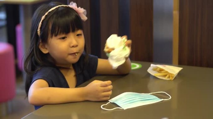 中国孩子在自助餐厅吃汉堡。